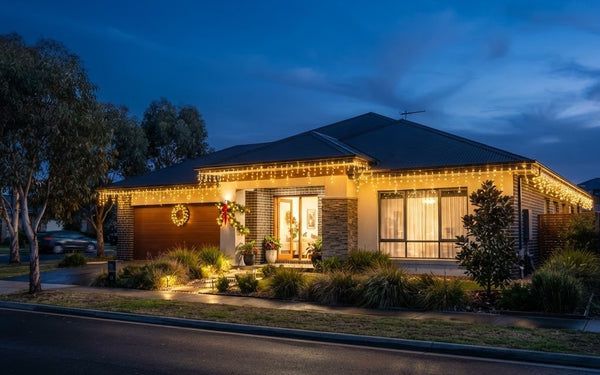 Icicle Christmas lights illuminating an Australian home roofline at twilight