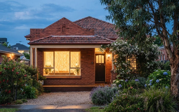 Christmas window lights glowing in a large window of an Australian home at dusk