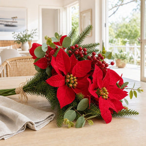 Deep Red Poinsettia and Eucalypt Bouquet Stem on a decorated Christmas tree