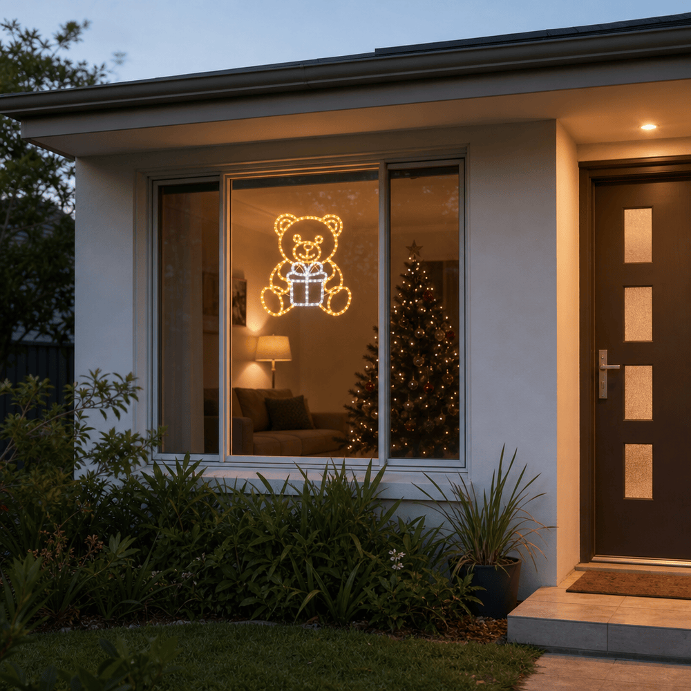 LED Acrylic Bear and Present Motif (42cm) hanging in a front window at night