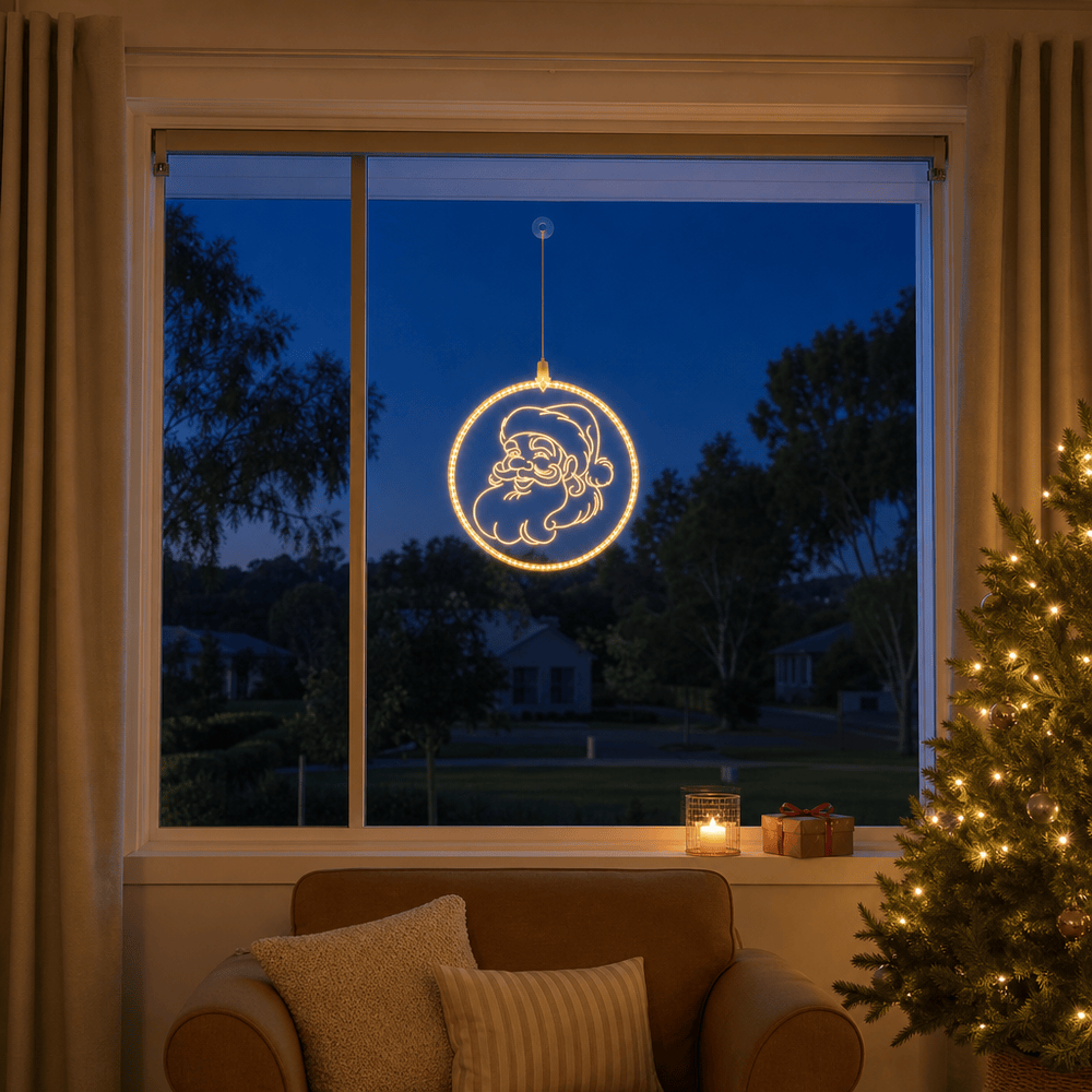 LED Santa Face Pendant Light Motif (30cm) glowing in a living room window at night