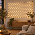 180 LED battery net light in warm white hung on a living room wall above a timber console